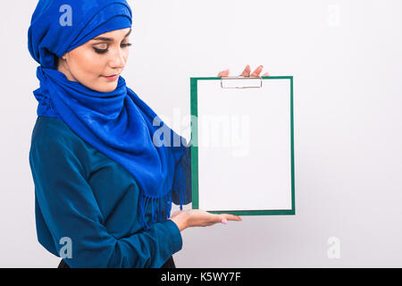 Ihren Text hier ein. Hübsche Junge aufgeregt arabische Frau Holding leer Blank Board. Farbenfrohe studio Portrait mit weißem Hintergrund. Stockfoto