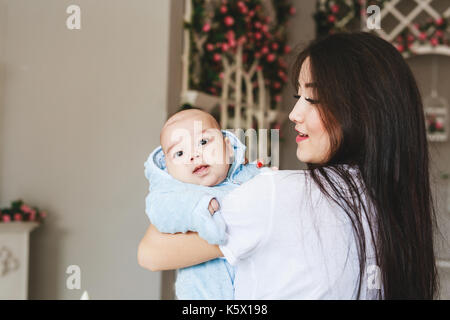 Lieben asiatischen Mutter Holding Baby Sohn zu Hause Stockfoto