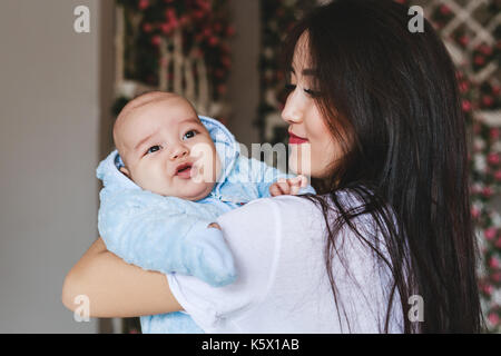 Lieben asiatischen Mutter Holding Baby Sohn zu Hause Stockfoto