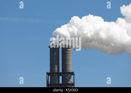 Weißen Smoking Fabrikschornsteinen vor einem blauen Himmel Stockfoto
