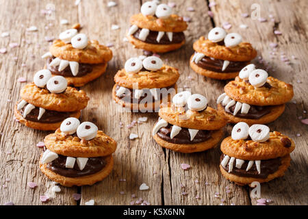 Heloween Dessert: lustige Monster aus Kekse mit Schokolade und marshmelow Close-up auf dem Tisch. Horizontale Stockfoto