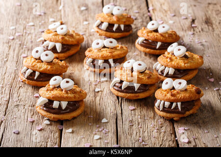 Halloween Dessert: lustige Monster aus Cookies close-up auf einem Tisch. Horizontale Stockfoto