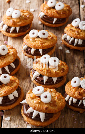 Halloween Essen: Monster der nussige Cookies mit Schokoladencreme close-up auf dem Tisch. Vertikale Stockfoto