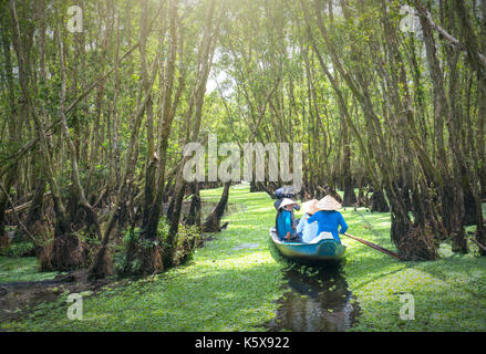Der Fährmann bringt Reisende auf einer Bootstour entlang der Kanäle im Mangrovenwald. Es ist ein Eco Tourismus Bereich am Mekong Delta Stockfoto