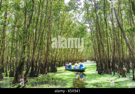 Der Fährmann bringt Reisende auf einer Bootstour entlang der Kanäle im Mangrovenwald. Es ist ein Eco Tourismus Bereich am Mekong Delta Stockfoto
