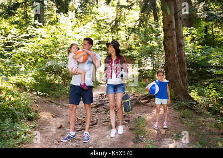 Schöne junge Familien mit Töchtern, Camping im Wald. Stockfoto