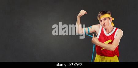 Eine lustige schlanke Mann in Sportswear Maßnahmen ein Mann in einem Zentimeter. Stockfoto