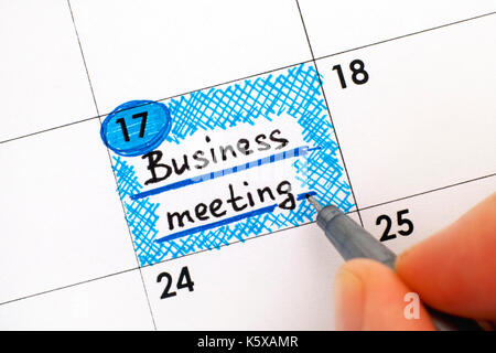 Frau Finger mit Pen schreiben Erinnerung Business Meeting in "Kalender". Close-up. Stockfoto