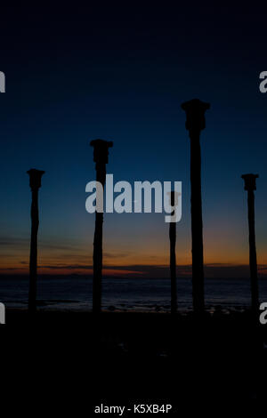 Die Säulen dock stehen mit Blick auf den Sonnenuntergang am Strand von Tedys Kupang, Indonesien Stockfoto