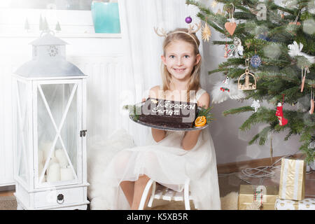 Girl holding Lebkuchen - Weihnachten - Begriff - Weihnachtsbaum, Geschenk und happynes Stockfoto