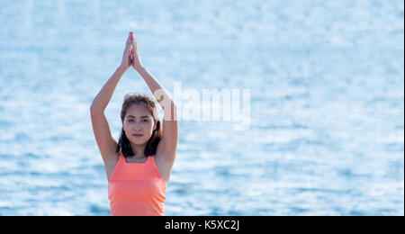 Close up Meisterin Yoga tun Tress am Strand und blaues Meer darstellen Stockfoto