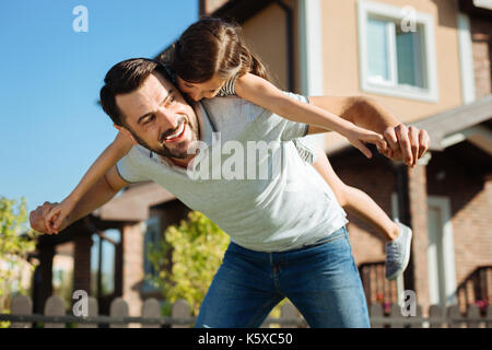 Upbeat Vater seiner Tochter, die auf der Rückseite Stockfoto