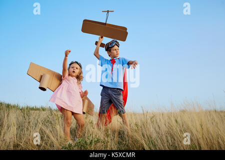 Bruder und Schwester in Anzügen von Superhelden Piloten gehen in n Stockfoto