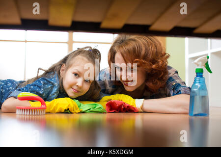 Mutter und Tochter sie die Reinigung im Haus. Glückliche Frau und Kind Mädchen wischte den Boden. Stockfoto