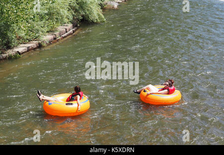 Golden, CO - August 12: Zwei nicht identifizierte weibliche profitieren Sie von einem schönen Sommertag und Schwimmer auf Rohre in Clear Creek, die durch das Abschleppen läuft Stockfoto