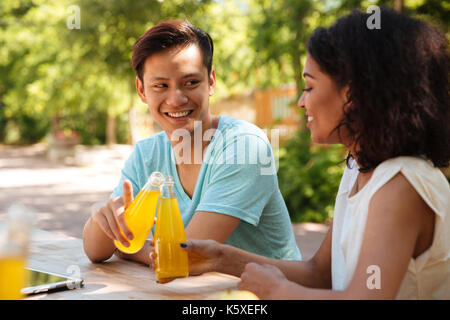 Glückliches Paar Sitzen im Freien durch die der Tabelle Stockfoto