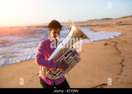 Musiker spielen auf der Tuba an der Küste. Stockfoto