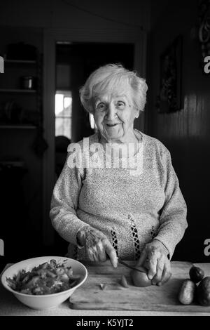 Eine ältere Frau bereitet den Salat. Der Schwarzweiß-Fotografie. Stockfoto