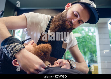 Junger Mann bereit für die Rasur im Friseursalon von einem Skill Bärtigen Stockfoto
