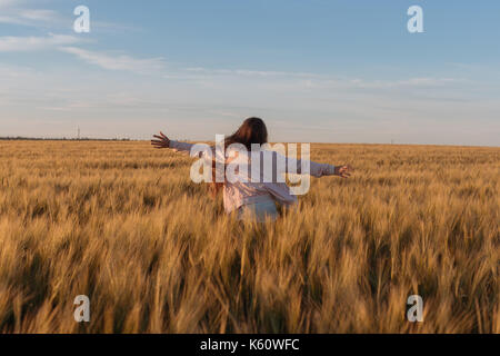 Junges Mädchen läuft im gelben Feld. Stockfoto