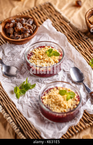 Torte mit roten Beeren in kleine Glasschale bröckeln Stockfoto