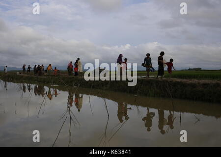 Teknaf, Bangladesch. September 2017. Rohingya Flüchtling geht schlammigen Weg nach der Überquerung der Bangladesch-Myanmar Grenze, in Teknaf. Rohingya Flüchtling geht schlammigen Weg nach der Überquerung der Bangladesch-Myanmar Grenze, in Teknaf. Quelle: Md. Mehedi Hasan/Pacific Press/Alamy Live News Stockfoto