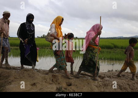 Teknaf, Bangladesch. September 2017. Rohingya Flüchtling geht schlammigen Weg nach der Überquerung der Bangladesch-Myanmar Grenze, in Teknaf. Rohingya Flüchtling geht schlammigen Weg nach der Überquerung der Bangladesch-Myanmar Grenze, in Teknaf. Quelle: Md. Mehedi Hasan/Pacific Press/Alamy Live News Stockfoto