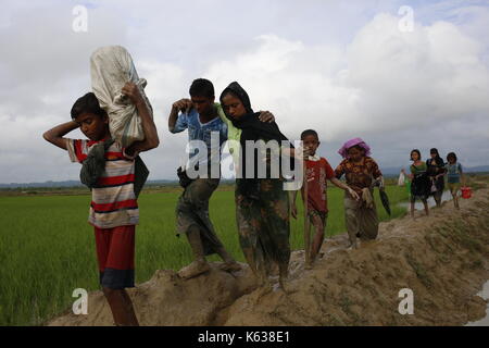 Teknaf, Bangladesch. September 2017. Rohingya Flüchtling geht schlammigen Weg nach der Überquerung der Bangladesch-Myanmar Grenze, in Teknaf. Rohingya Flüchtling geht schlammigen Weg nach der Überquerung der Bangladesch-Myanmar Grenze, in Teknaf. Quelle: Md. Mehedi Hasan/Pacific Press/Alamy Live News Stockfoto