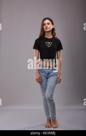 Werbung und T-shirt Design Konzept. Portrait von stilvolle Frau mit schwarzen T-Shirt mit der Aufschrift questoin Mark und Blue Jeans gegen Ständigen Stockfoto