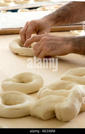 Die männlichen Bäcker Teig für Bagels in Bäckerei Stockfoto