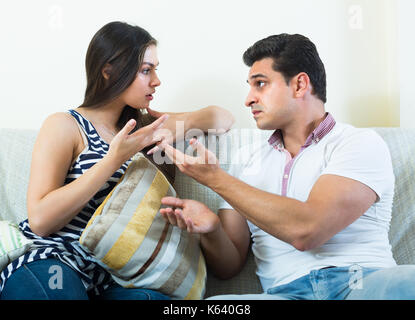 Gespräch zwischen Mann und seine attraktiven jungen langhaarigen Frau zu Hause Stockfoto