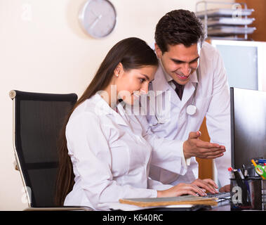Positive junge intern fragen Beratung von Arzt an der Klinik der Rezeption. Fokus auf Frau Stockfoto