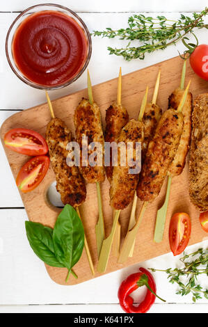 Lula Kebab ist ein traditionelles asiatisches Gericht. Gehackte gebratenes Fleisch am Spieß. Dienen auf einem Brett mit Müsli Ciabatta, Tomaten. Ansicht von oben. Stockfoto