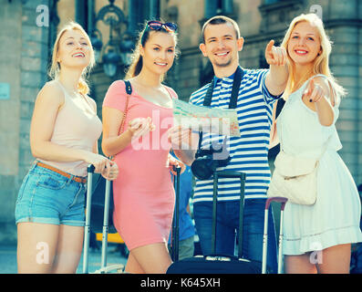 Gruppe von Smilling Touristen stehen im Freien mit Karte und Koffer Stockfoto
