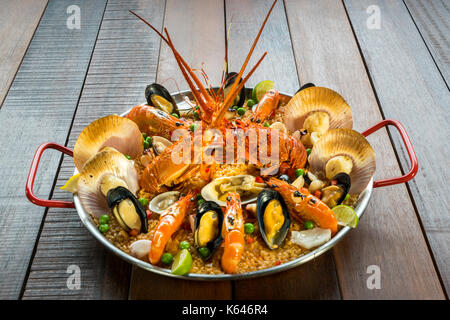 Gourmet Meeresfrüchte Valencia Paella mit frischen Scampi, Muscheln, Muscheln und Tintenfisch auf herzhafte Safran Reis mit Garnelen, scollops, Muscheln und Kalk schichten, Stockfoto