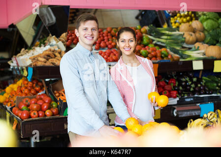 Lächelnden jungen Kunden, Orangen, Zitronen, Mandarinen im Lebensmittelgeschäft Abschnitt Stockfoto