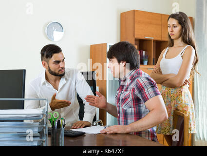 Junge Chef und merried Ehepaar miteinander reden mit ernsten Gesichtsausdruck im Büro Stockfoto