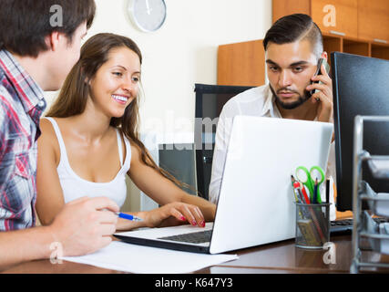 Die Gruppe der erwachsenen Leuten Spaß, während etwas aufpassen auf Laptop Stockfoto