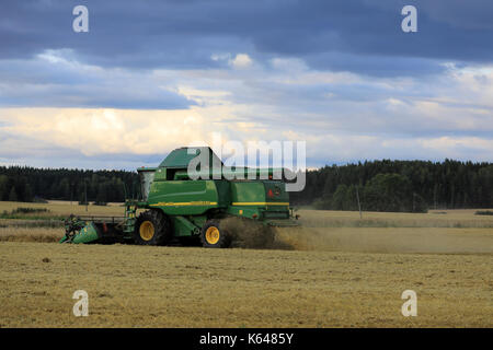 SALO, Finnland - 25. AUGUST 2017: Getreideernte mit John Deere Mähdrescher 9460 habe ich an einem Herbstabend im ländlichen Süden Finnlands. Stockfoto