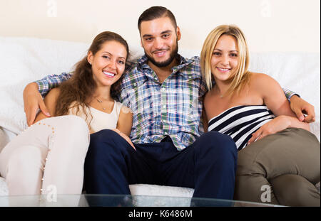 Lächelnd modernen polygamen Familie mit einem Mann und zwei Frauen Stockfoto