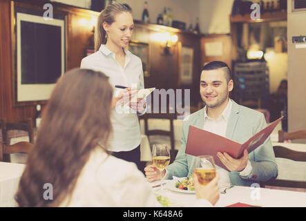 Gut aussehender Mann mit schönen glücklich Freundin macht Ordnung im café Stockfoto