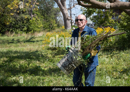 Detroit, Michigan - Personen mit Wohnsitz in der Gemeinschaft und die Mitglieder der Knights of Columbus sauber Papierkorb und Bürste aus Baulücken in der Morningside Nachbarschaft. Stockfoto