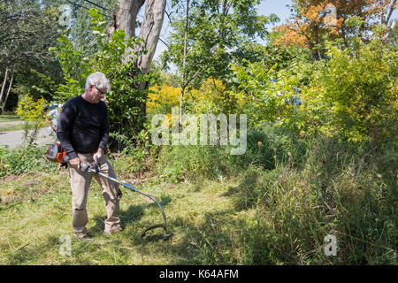 Detroit, Michigan - Personen mit Wohnsitz in der Gemeinschaft und die Mitglieder der Knights of Columbus sauber Papierkorb und Bürste aus Baulücken in der Morningside Nachbarschaft. Stockfoto