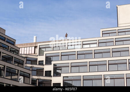 Eine lebensgroße Gusseisen Skulptur von Antony Gormley auf dem Dach der Bibliothek an der Universität von East Anglia, Norwich, UK. Stockfoto