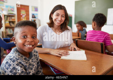 Lehrerin und Grundschule Junge lächelnd in die Kamera Stockfoto