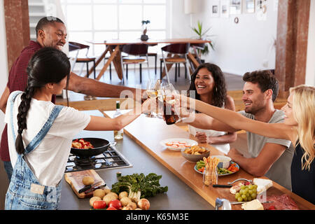 Freunde bereiten und servieren Speisen zum Abendessen Partei zu Hause zusammen Stockfoto