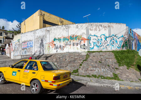 Gelbe Taxi und Straßenrand Urban Art und Graffiti an der Wand in einem Vorort von Quito, der Hauptstadt von Ecuador, Südamerika, eine typische Straße Szene Stockfoto