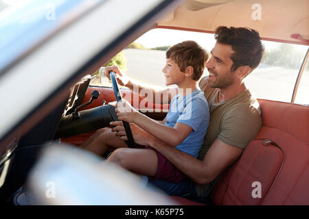 Vater Unterrichten junger Sohn zu fahren Auto auf Reise Stockfoto