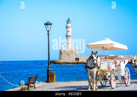 Blick auf den alten Hafen von Chania mit Pferdekutschen und Leuchtturm, Kreta, Griechenland. Stockfoto