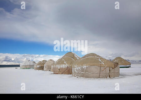 Jurten im traditionellen kirgisischen Jurtenlager im Schnee entlang des Song Kul / Song Kol Sees im Tian Shan Gebirge, Provinz Naryn, Kirgisistan Stockfoto